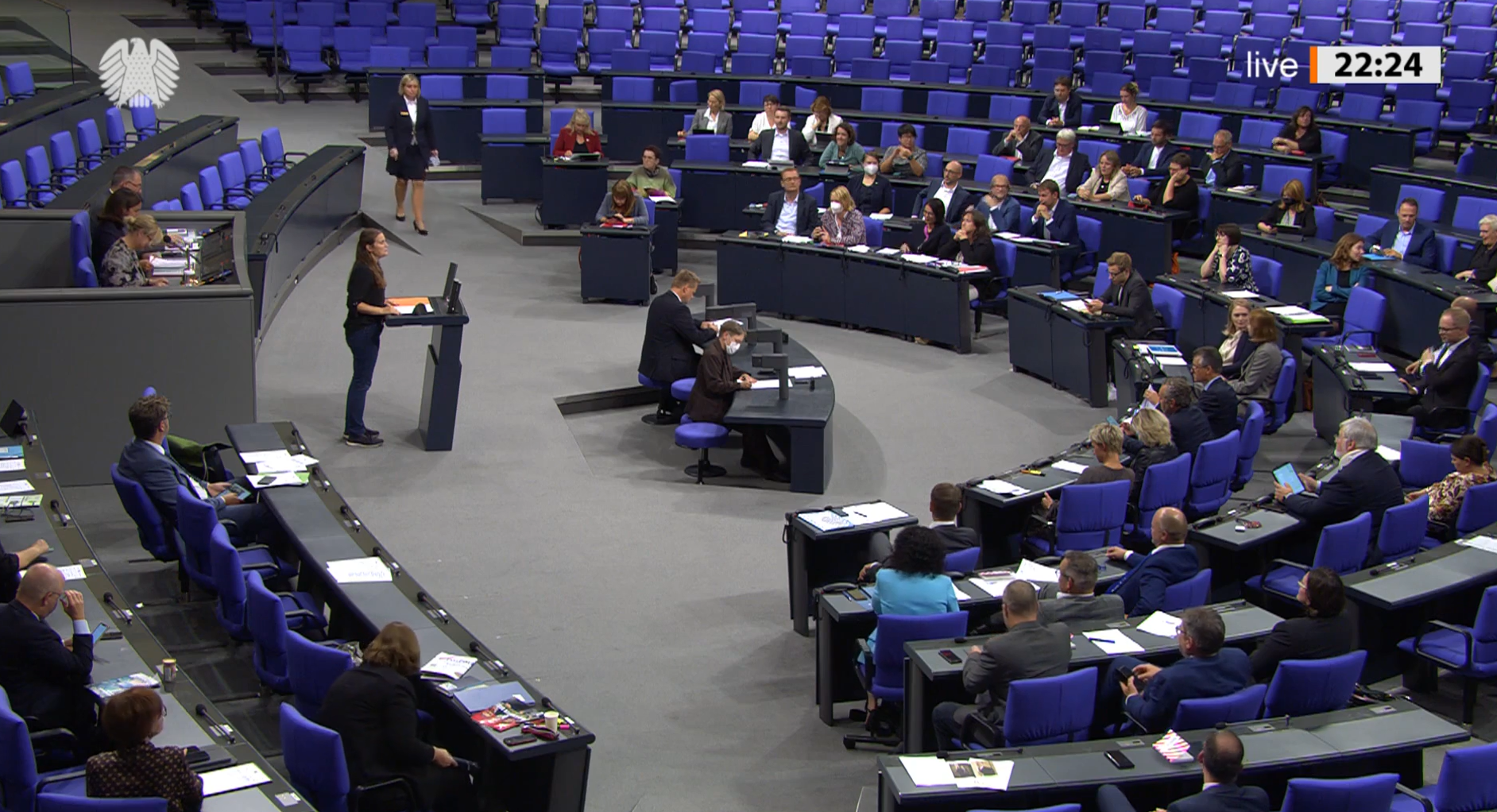 Maja Wallstein, MdB steht am Rednerpult des Deutschen Bundestages zu ihrer dritten Rede - Totale mit Blick in die Reihen des Plenums